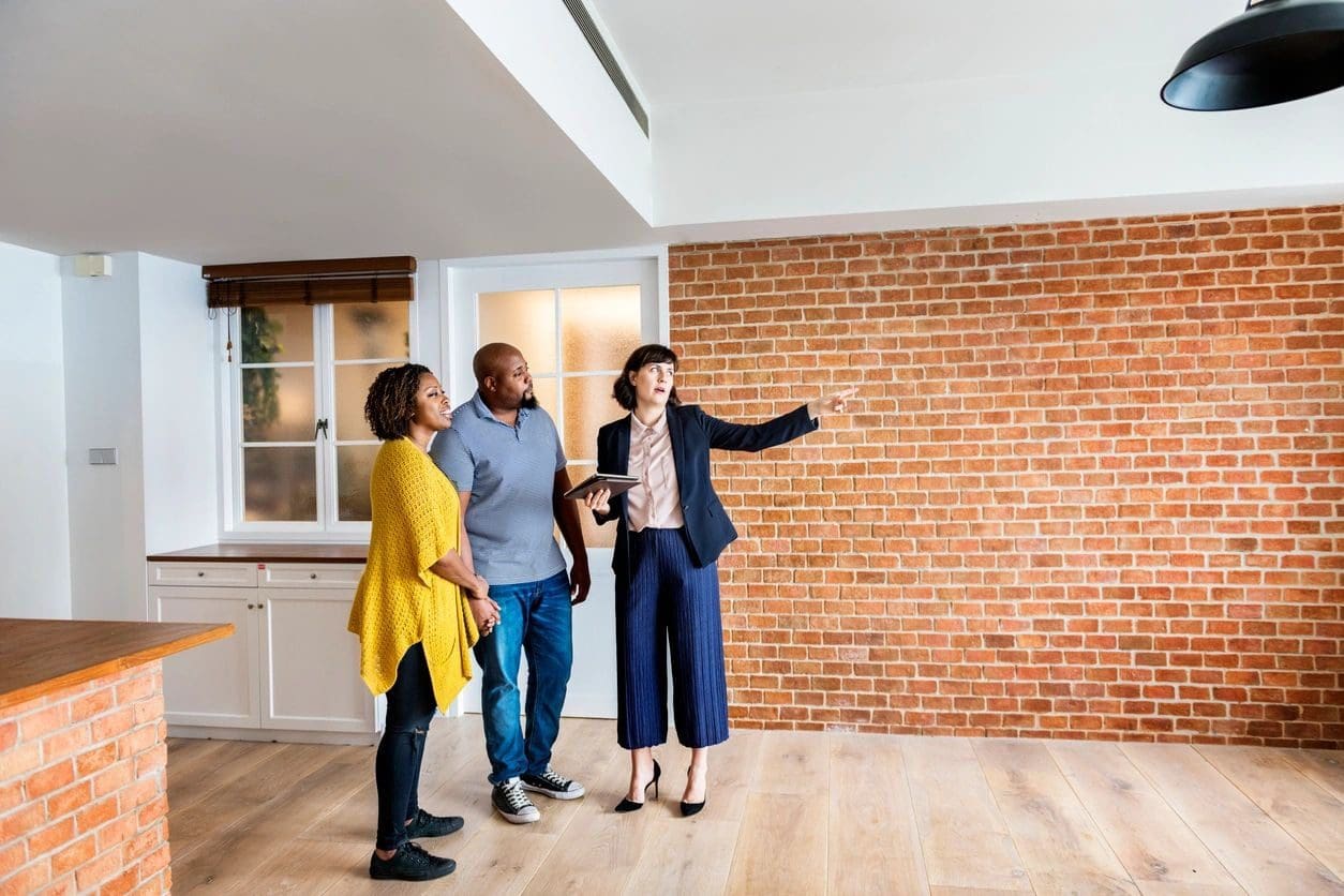 A group of people standing in front of a brick wall.