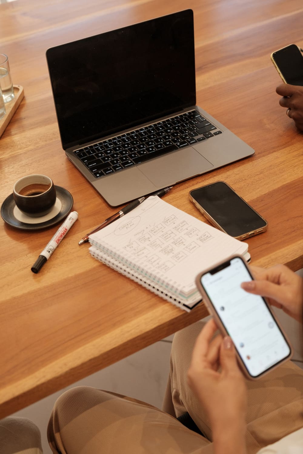 A person is using their phone while sitting at the table.